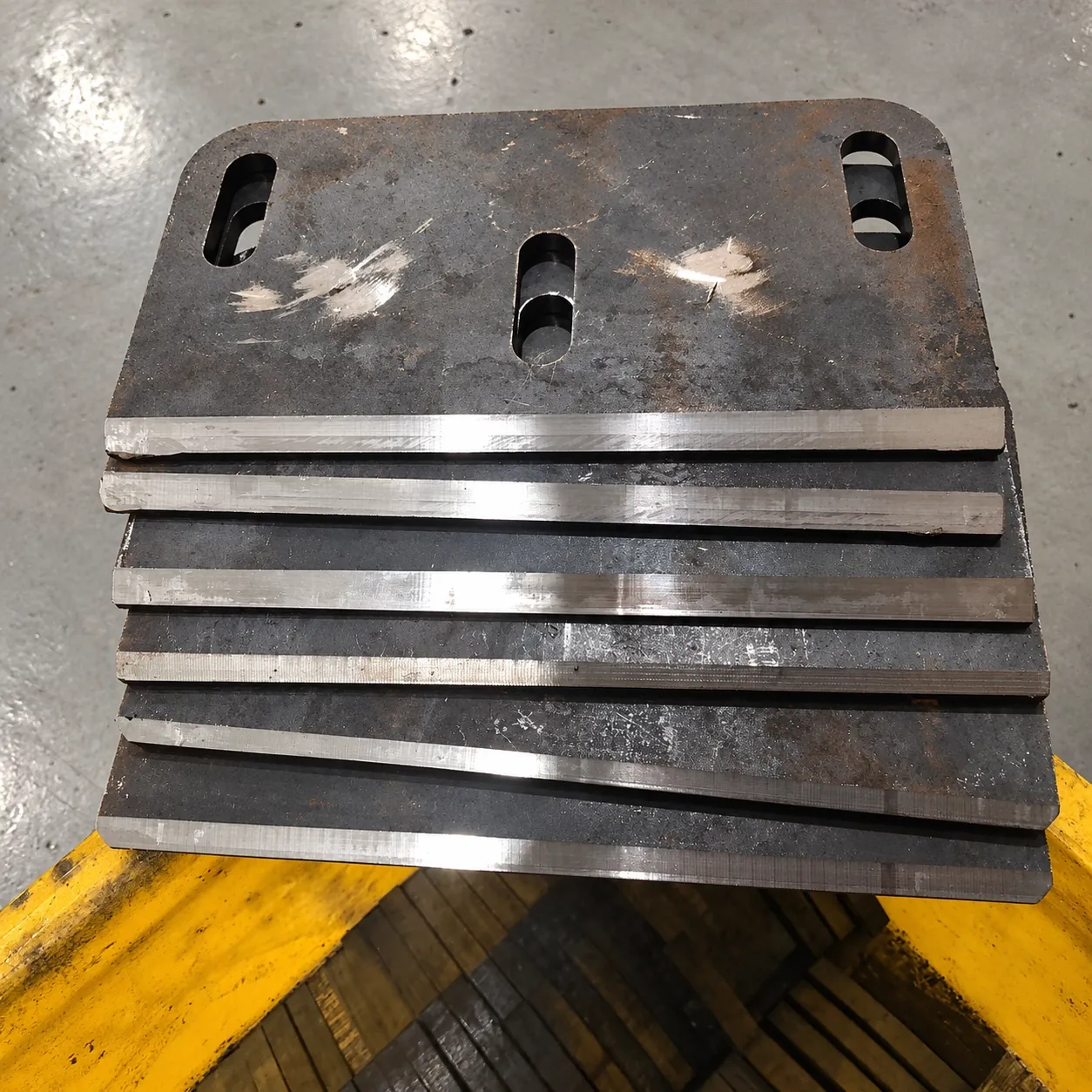 Stack of slotted steel plates with edges bevelled on the DZ benchtop edge miller