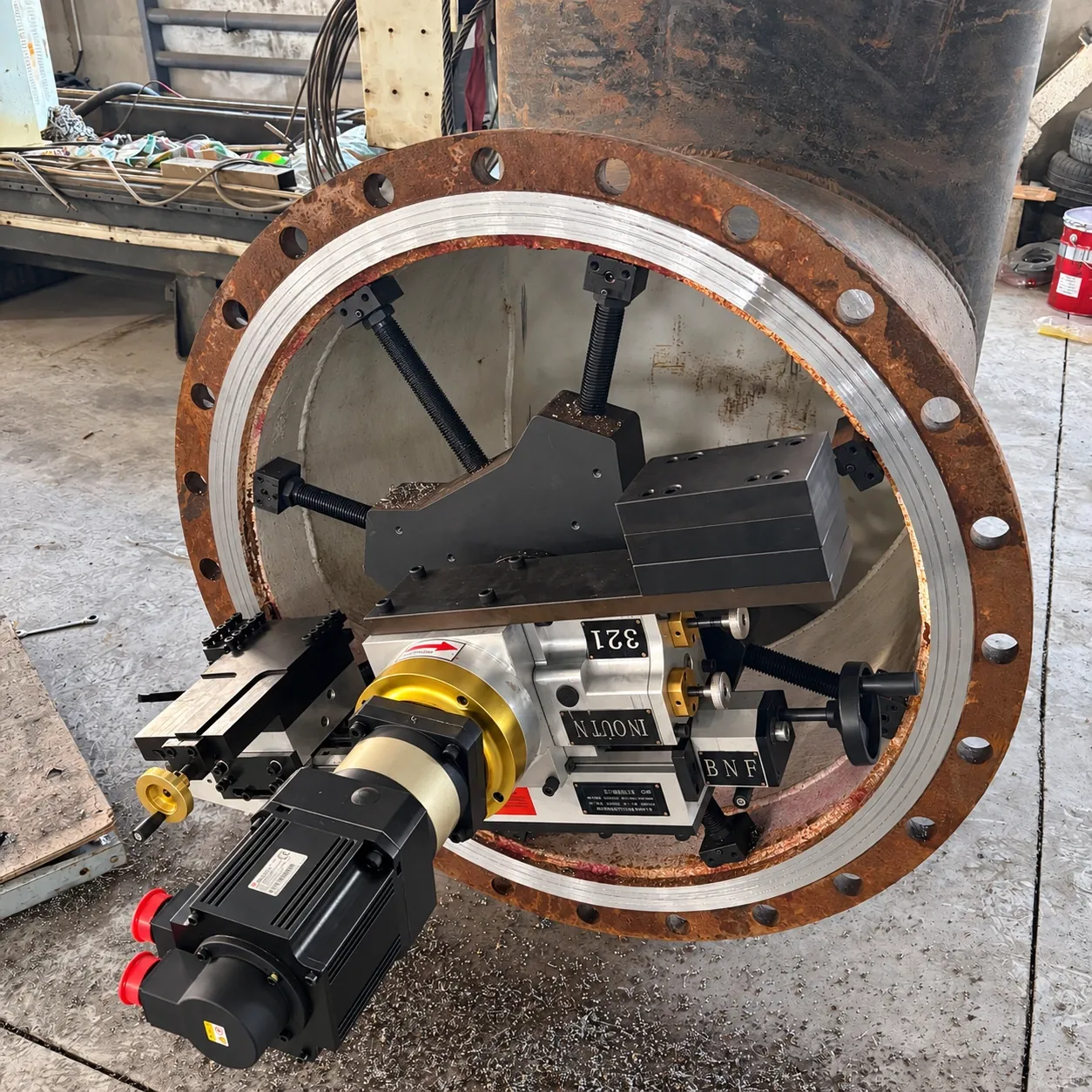 Portable flange facer clamped in a vertical nozzle flange, servo drive on the tool arm